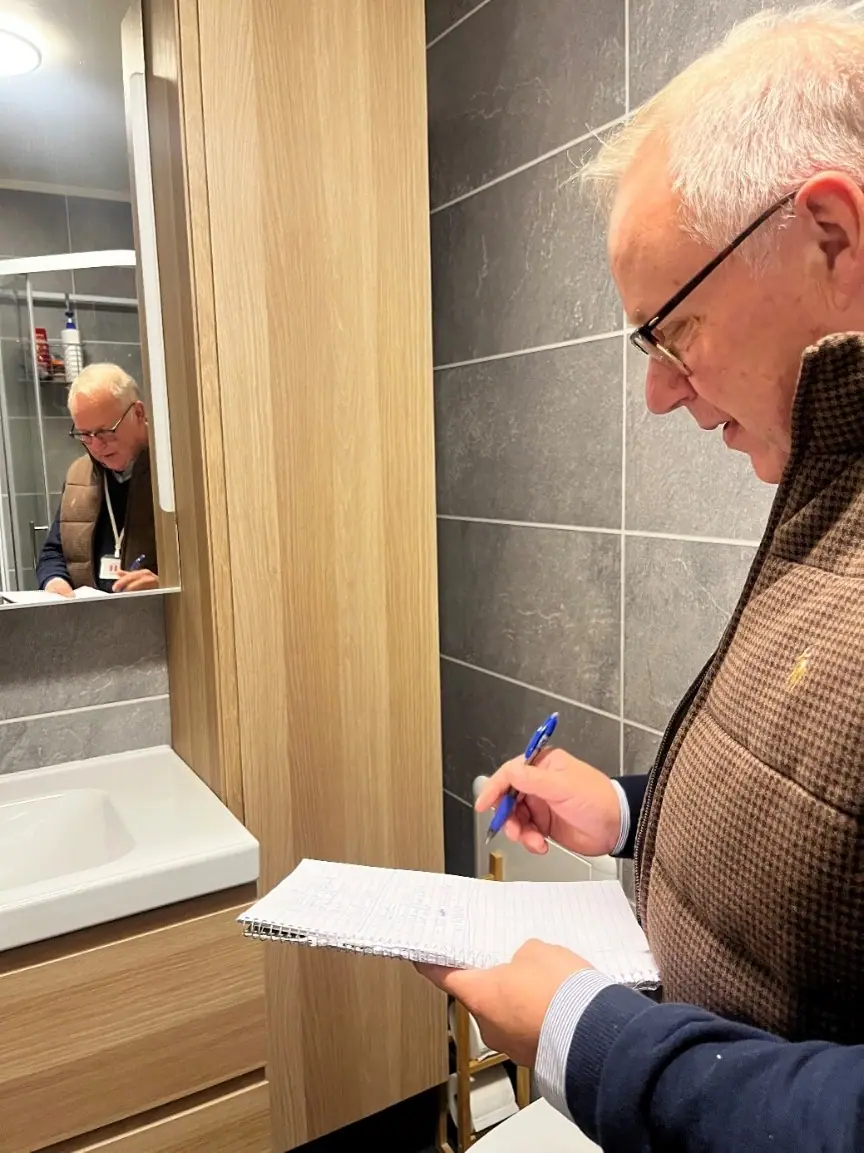 Surveyor taking notes while inspecting the bathroom